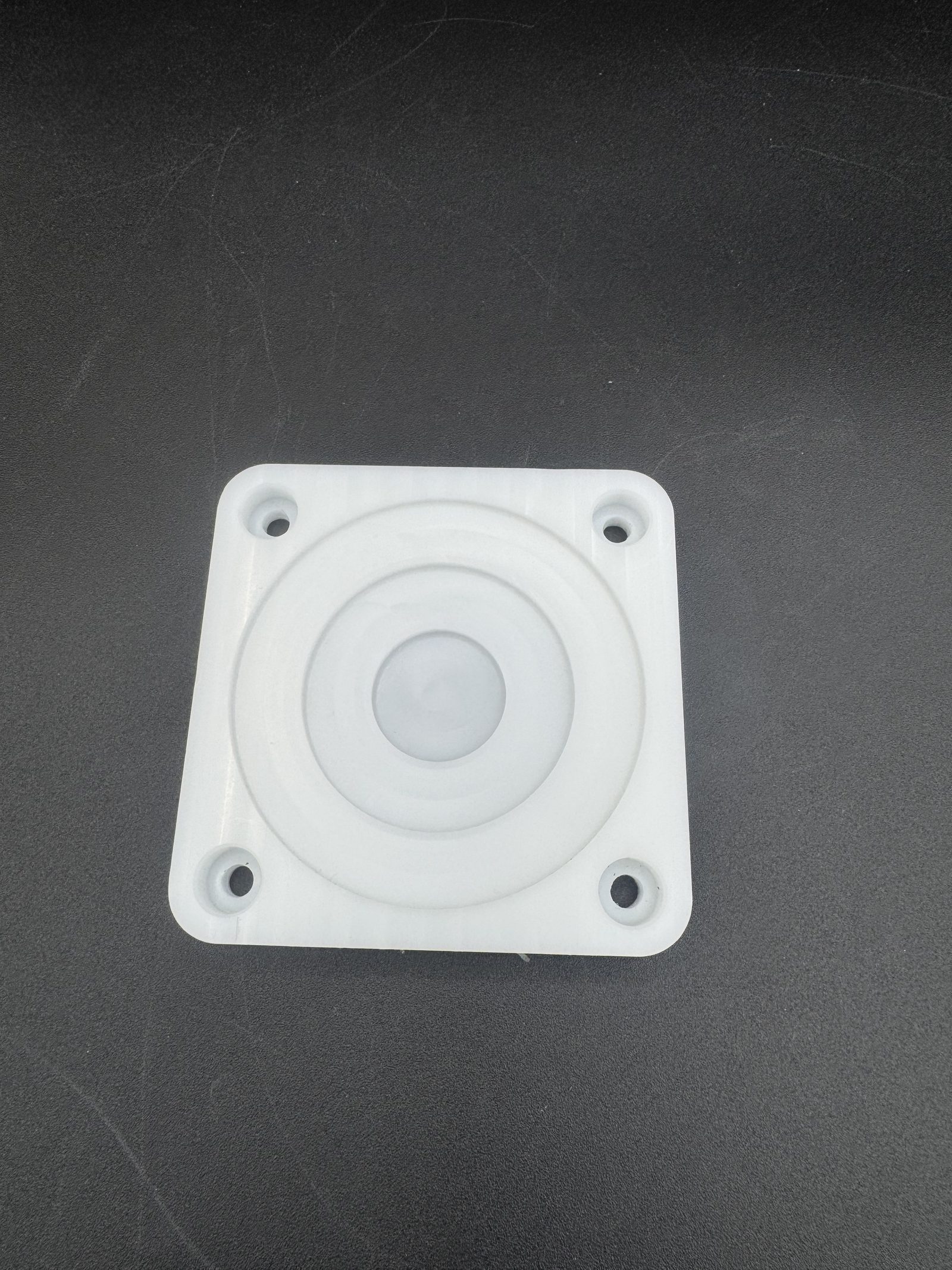 A square coaster with a concentric circular pattern, machined on a CNC mill